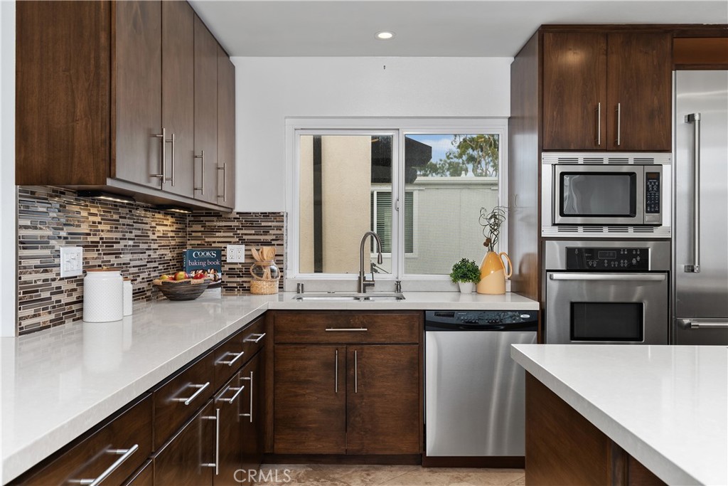 154 12th Street Seal Beach, CA 90740 - Photo 17 of 39 a kitchen with stainless steel appliances a sink a stove a refrigerator cabinets and a counter space