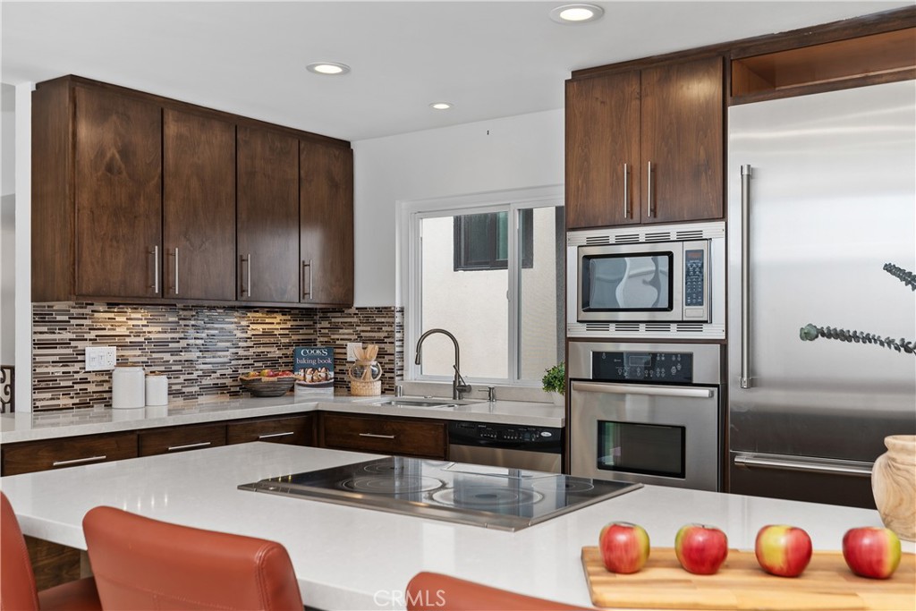 154 12th Street Seal Beach, CA 90740 - Photo 21 of 39 a kitchen with stainless steel appliances granite countertop a sink dishwasher stove and microwave with wooden floor
