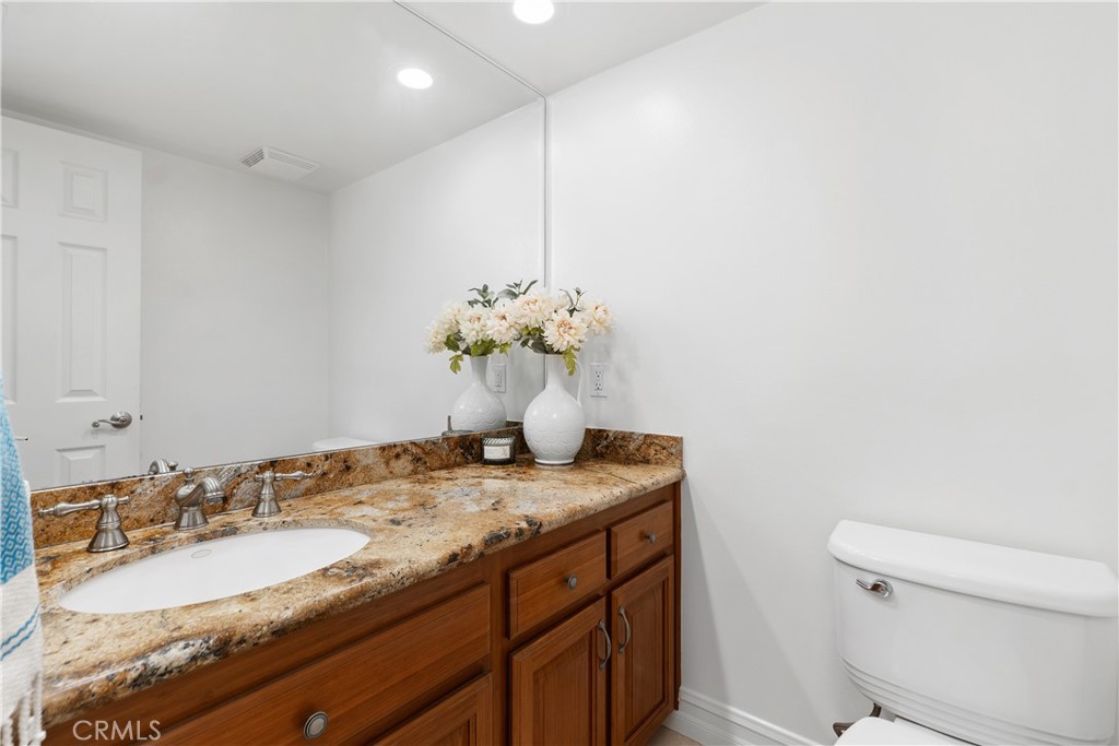 154 12th Street Seal Beach, CA 90740 - Photo 23 of 39 a bathroom with a granite countertop sink a toilet and a mirror