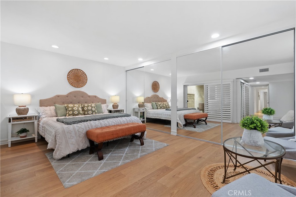 154 12th Street Seal Beach, CA 90740 - Photo 28 of 39 a spacious bedroom with a bed and a chandelier