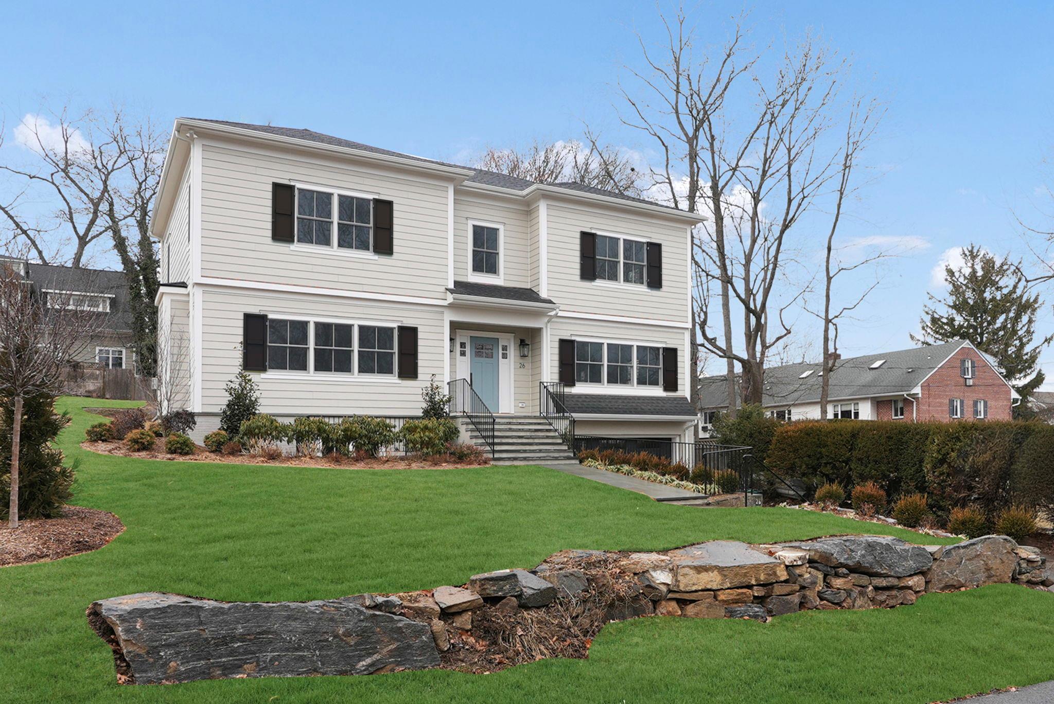 a front view of a house with a garden and yard