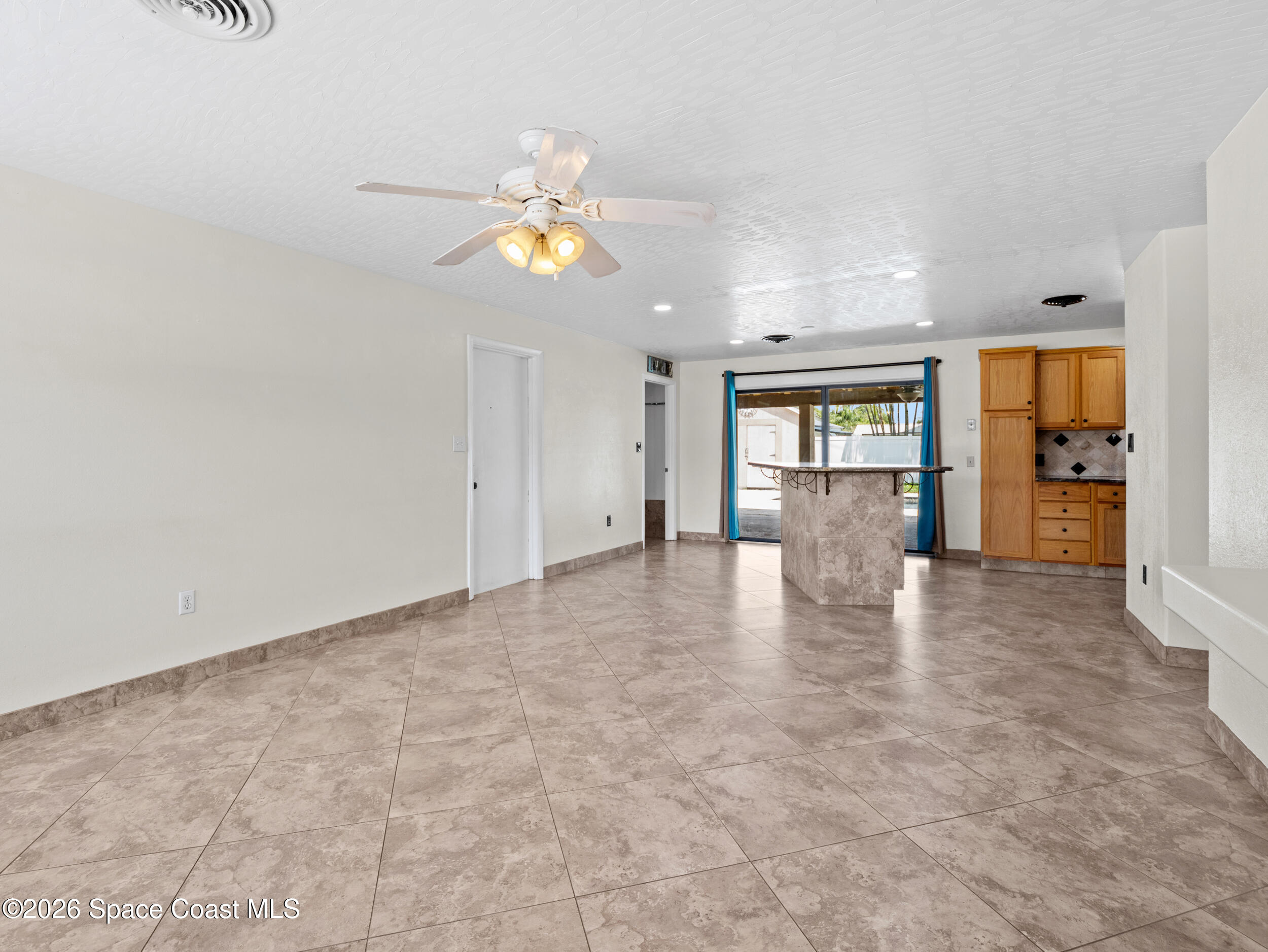 406 Amherst Avenue Melbourne, FL 32901 - Photo 14 of 36 an empty room with kitchen view and wooden floor