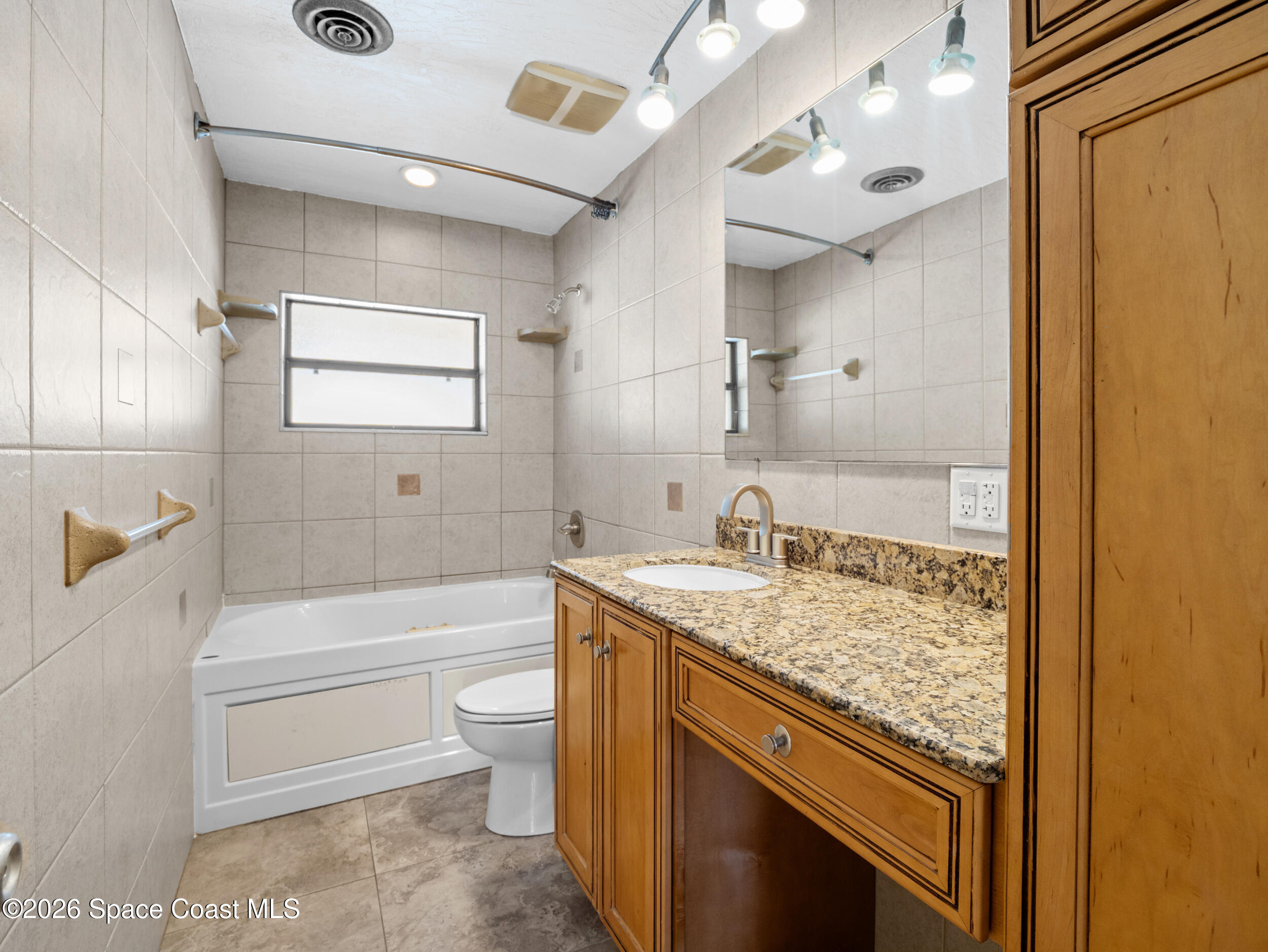 406 Amherst Avenue Melbourne, FL 32901 - Photo 19 of 36 a bathroom with a granite countertop sink a toilet and bathtub