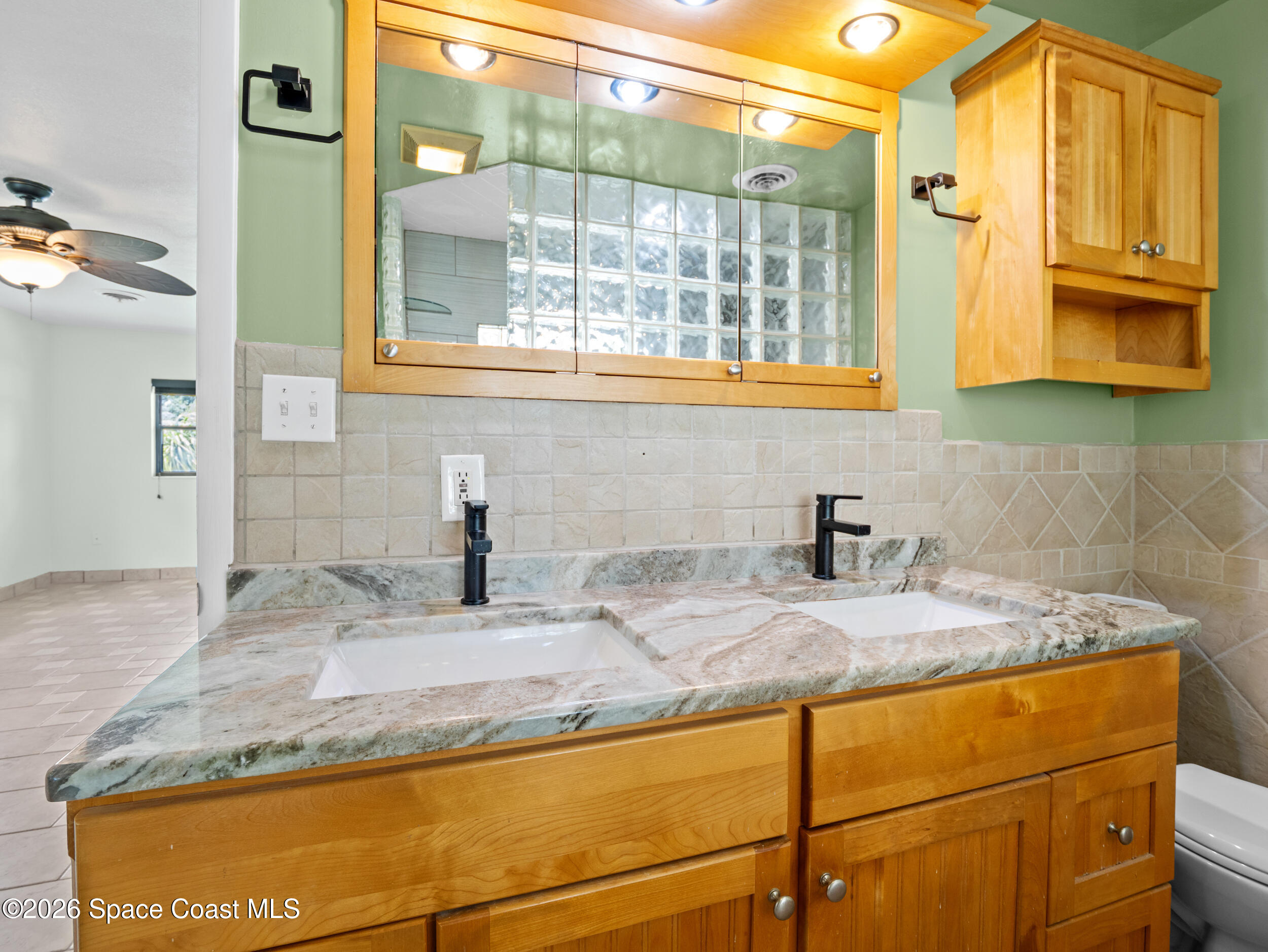 406 Amherst Avenue Melbourne, FL 32901 - Photo 23 of 36 a bathroom with a granite countertop sink and a mirror