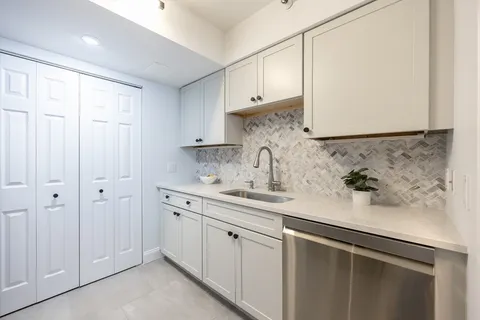a kitchen with stainless steel appliances granite countertop white cabinets and a sink