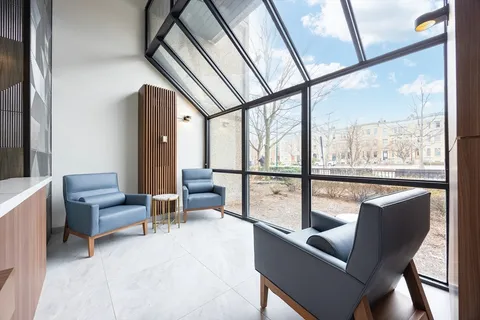 a living room with furniture and a floor to ceiling window