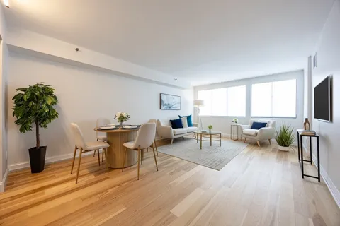 a living room with furniture a wooden floor and a flat screen tv