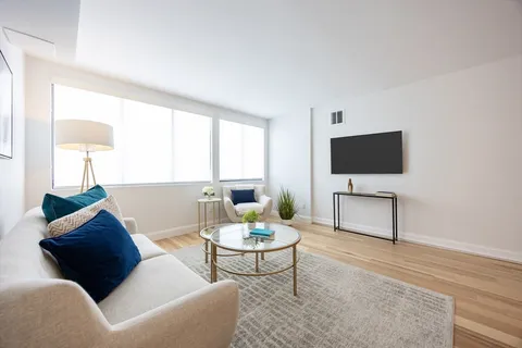 a living room with furniture a window and a flat screen tv