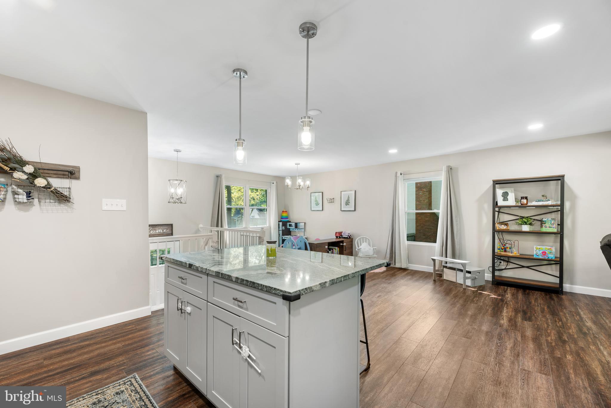 5756 Stephen Reid Road Huntingtown, MD 20639 - Photo 19 of 42 a kitchen with granite countertop a oven a sink a dining table and chairs with wooden floor