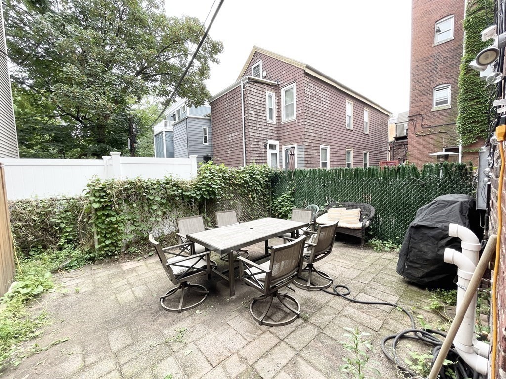 98 L Street, Unit STREET Boston, MA 02127 - Photo 19 of 19 a roof deck with table and chairs and potted plants