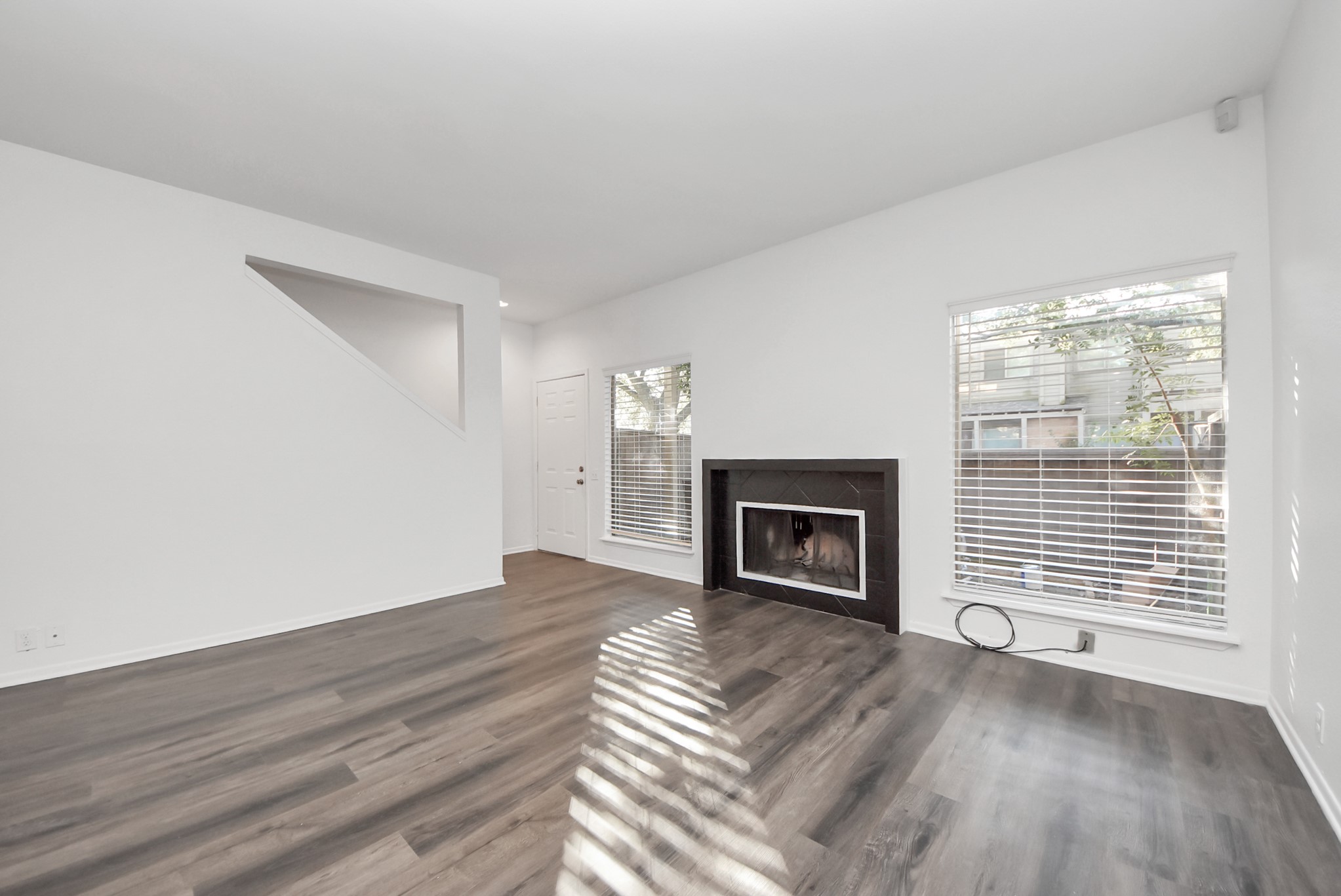 1635 Prairie Mark Lane Houston, TX 77077 - Photo 24 of 32 a view of an empty room with wooden floor fireplace and a window