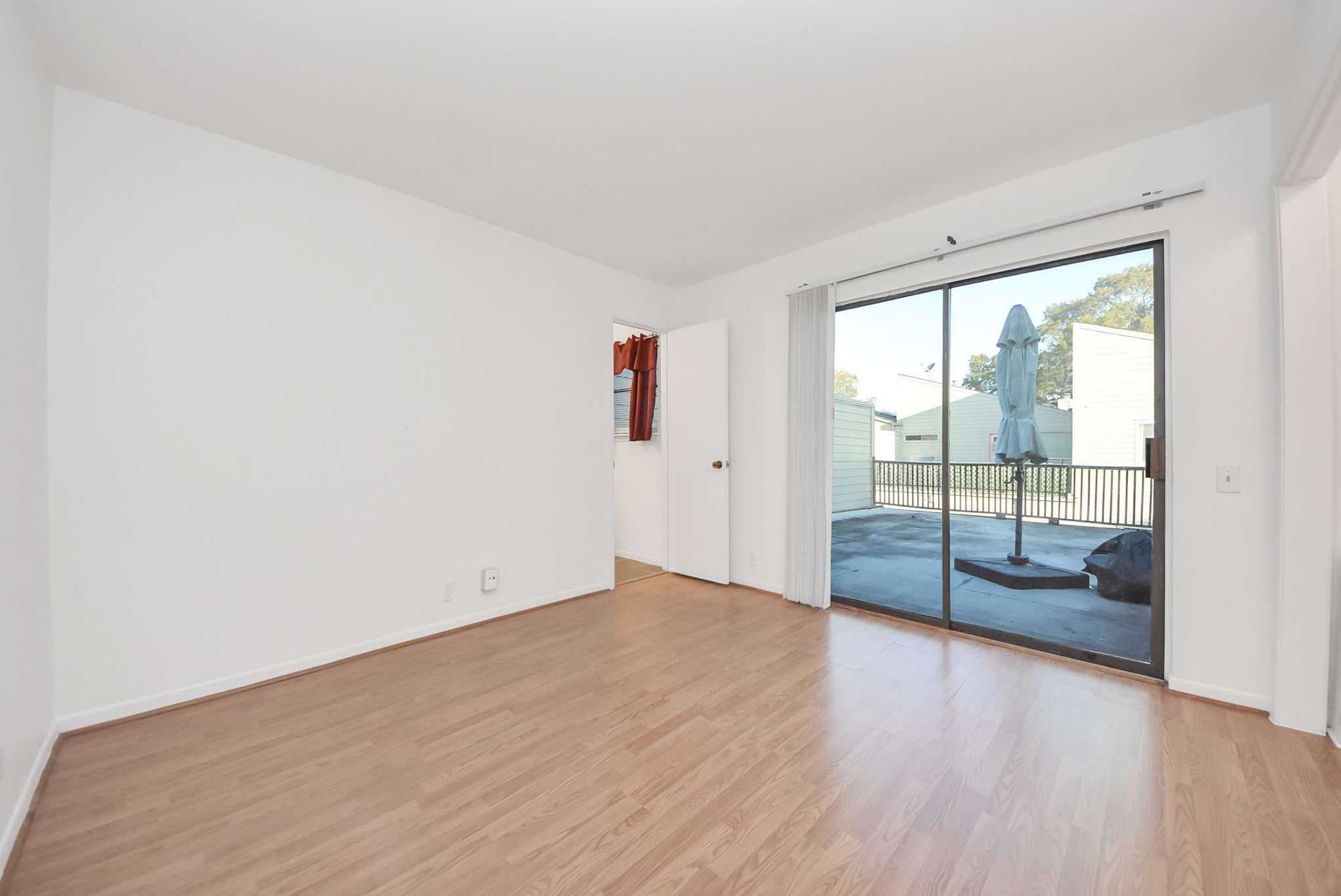 1635 Prairie Mark Lane Houston, TX 77077 - Photo 6 of 32 an empty room with wooden floor and sliding door