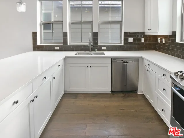 a kitchen with stainless steel appliances a sink and cabinets