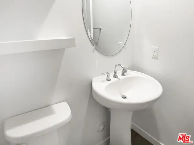 a bathroom with a sink a toilet and mirror
