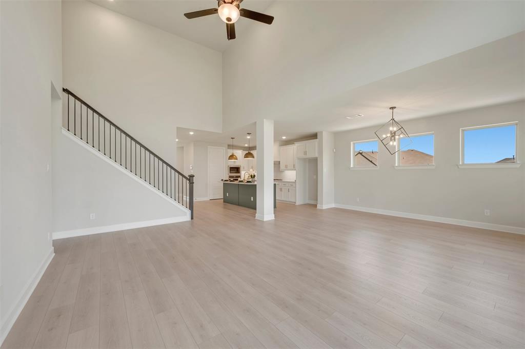 4308 Palomino Road Aubrey, TX 76227 - Photo 22 of 40 a view of a livingroom with wooden floor a ceiling fan and windows