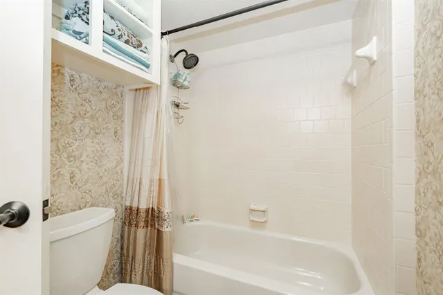 a white bath tub sitting next to a white toilet