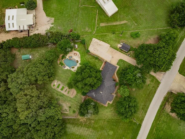 an aerial view of a house with a yard basket ball court and outdoor seating