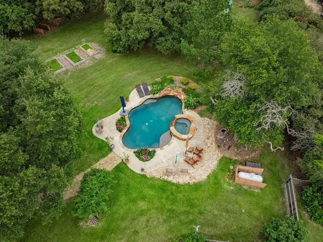 an aerial view of a house with outdoor space pool seating area and yard