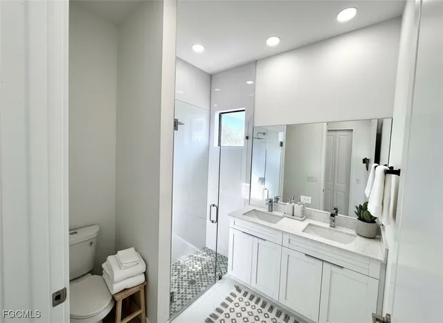 a bathroom with a double vanity sink toilet and shower