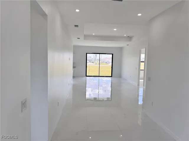 a view of hallway with window and wooden floor