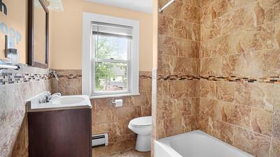 104-28 201st Street Queens, NY 11412 - Photo 9 of 13 Full bathroom with a baseboard heating unit, tile walls, vanity, wainscoting, and shower / bathtub combination