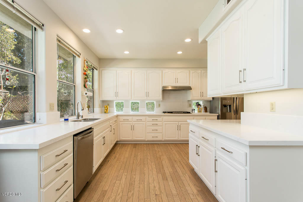 11691 Pinedale Road Moorpark, CA 93021 - Photo 12 of 37 a large kitchen with stainless steel appliances lots of white cabinets and wooden floors