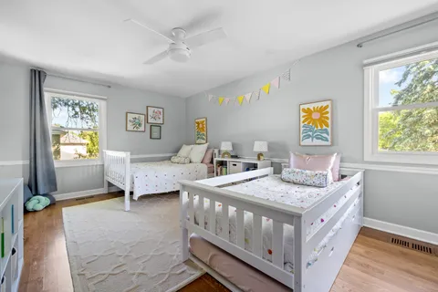 a bedroom with 2 bed and a window
