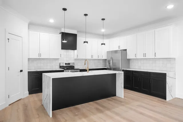 a kitchen with kitchen island a sink dishwasher a stove and a refrigerator with wooden floor