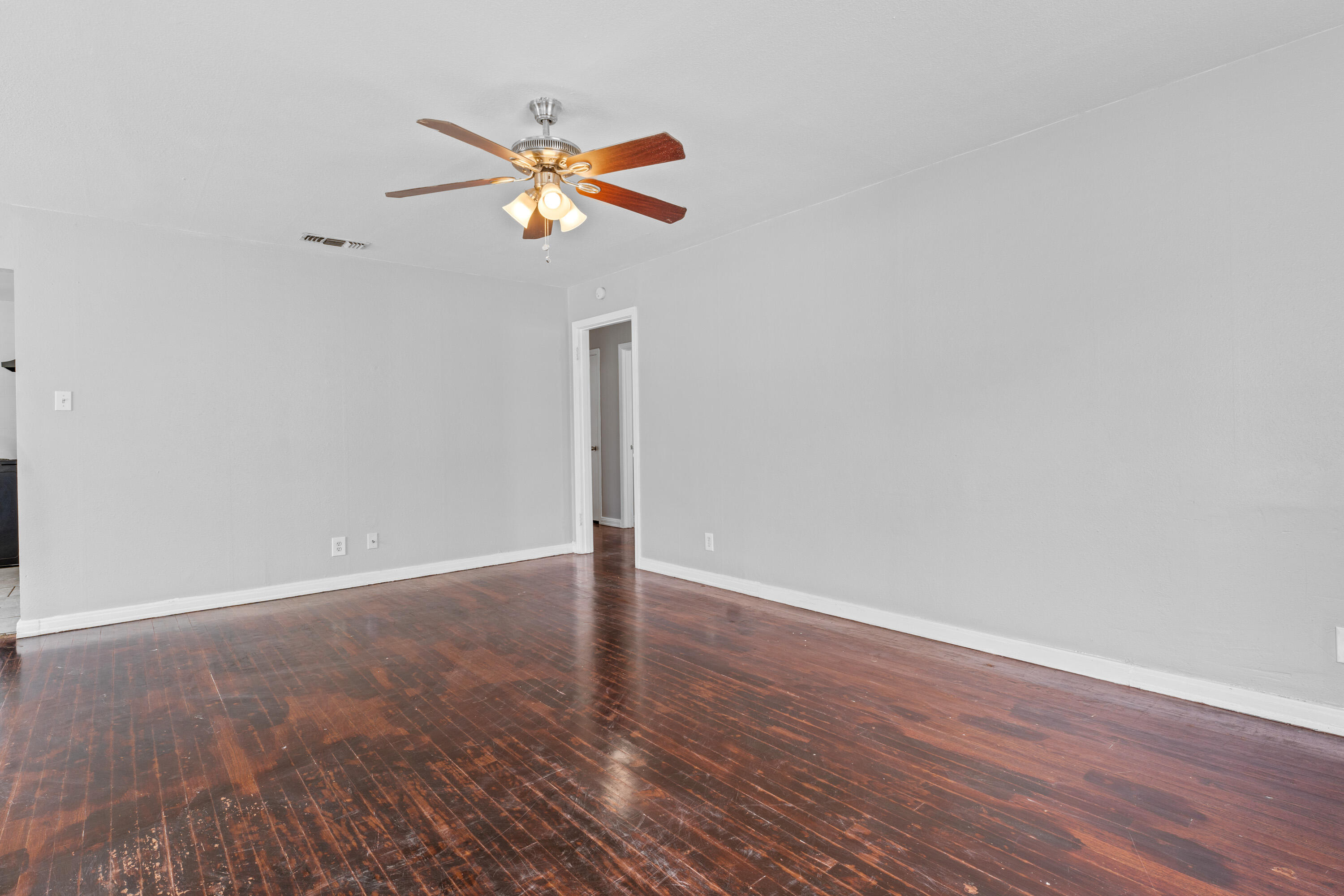 3313 26th Street Lubbock, TX 79410 - Photo 3 of 21 a view of an empty room with wooden floor and a ceiling fan
