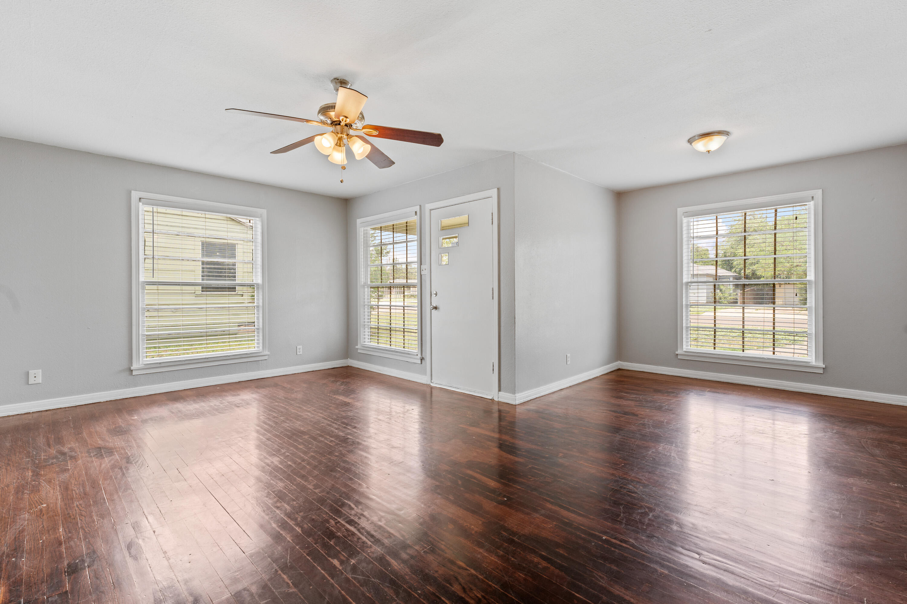 3313 26th Street Lubbock, TX 79410 - Photo 5 of 21 a view of an empty room with wooden floor and a window