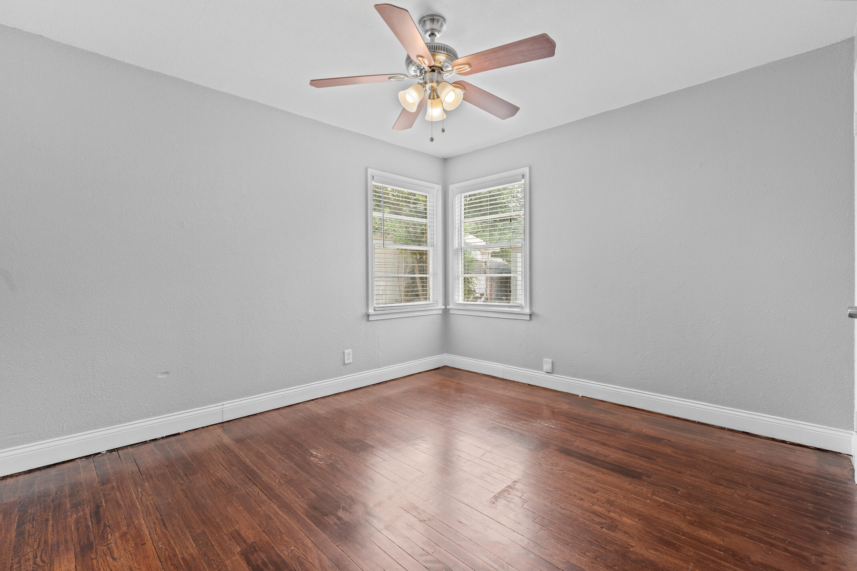 3313 26th Street Lubbock, TX 79410 - Photo 10 of 21 an empty room with wooden floor chandelier fan and windows