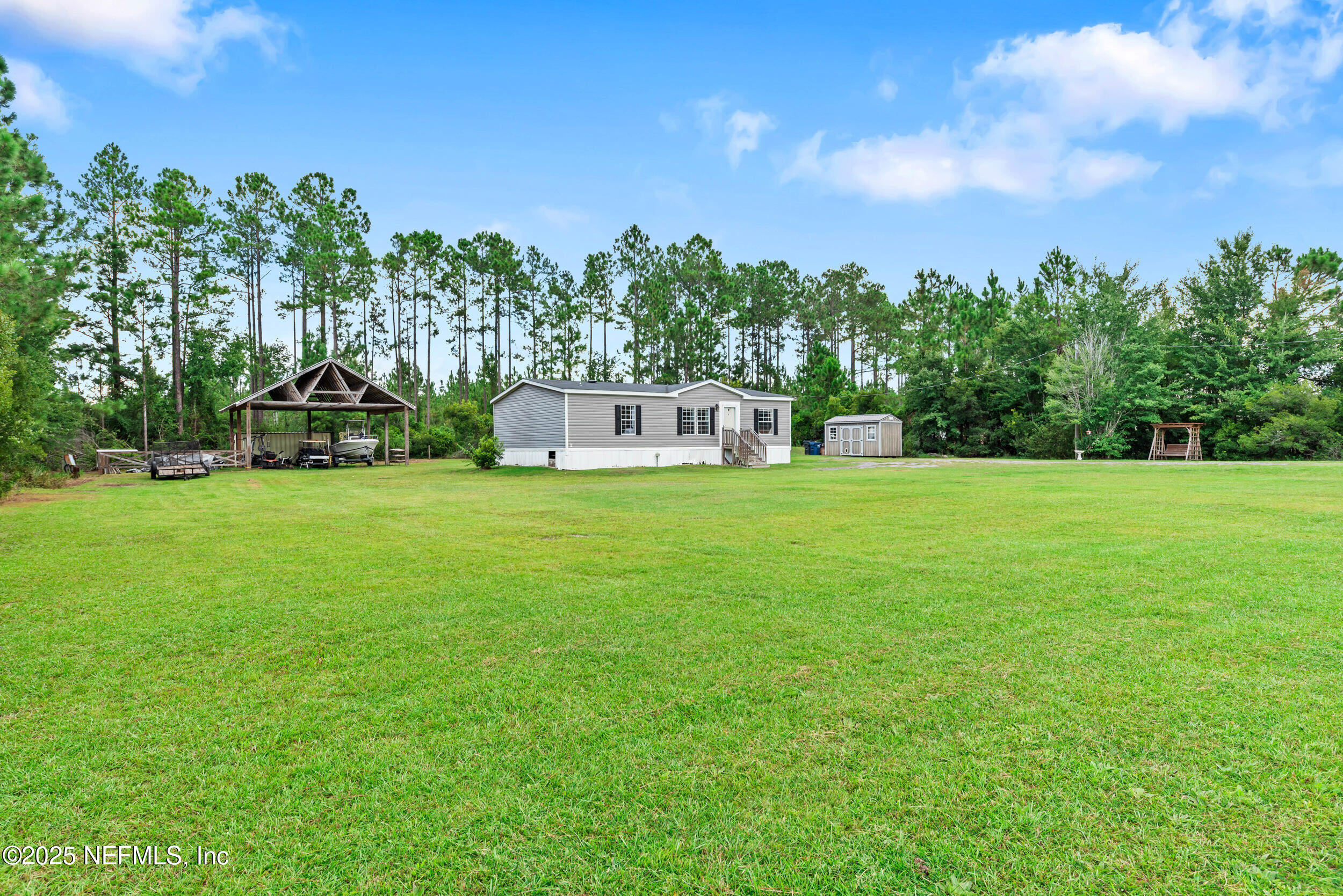 a view of a house with a big yard and large trees