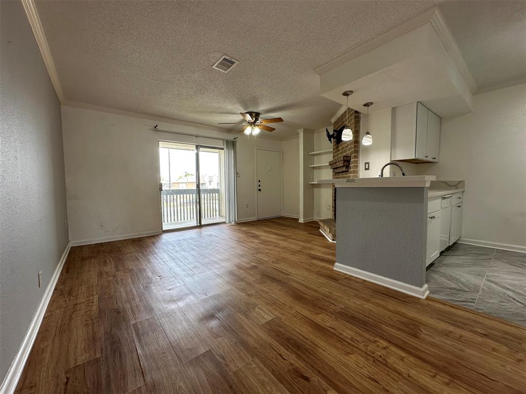 a view of a kitchen with wooden floor and a sink