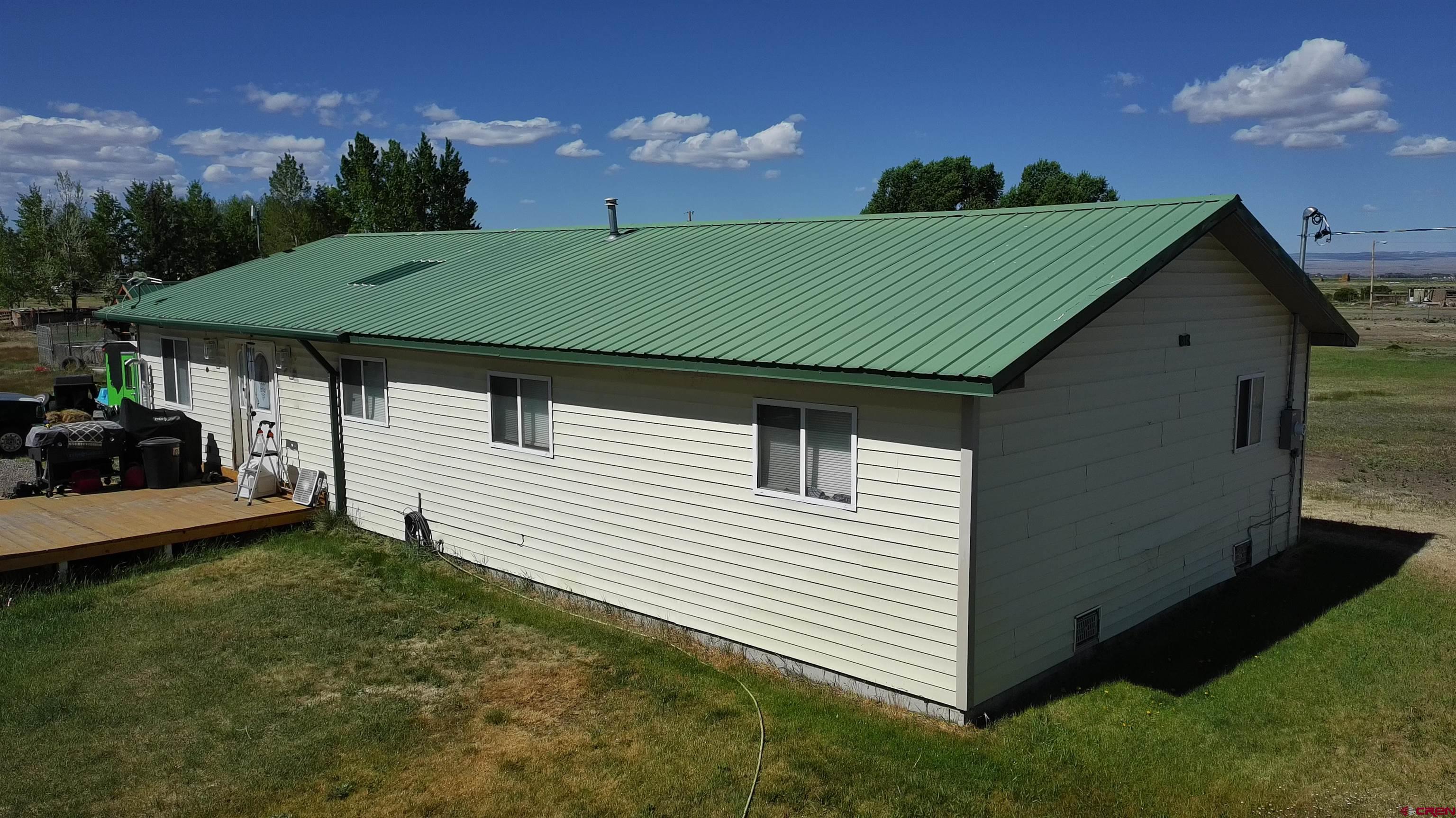 816 Main Street Manassa, CO 81141 - Photo 2 of 23 a backyard of a house with lots of green space