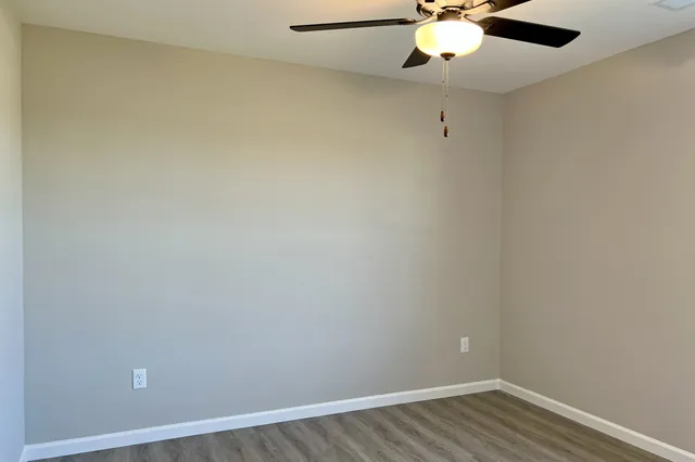 a view of an empty room with wooden floor