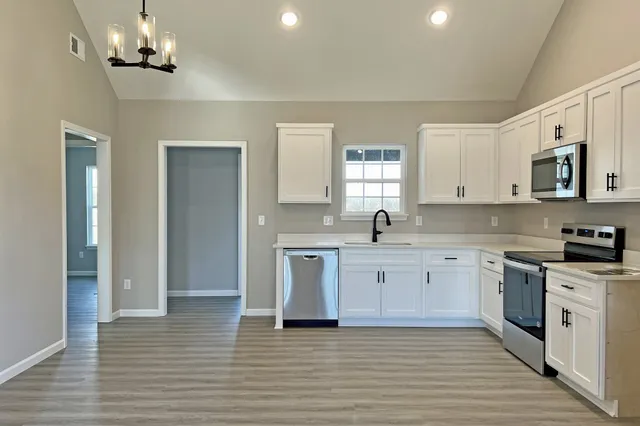 a kitchen with stainless steel appliances granite countertop a stove and cabinets