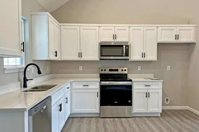 a kitchen with white cabinets and stainless steel appliances