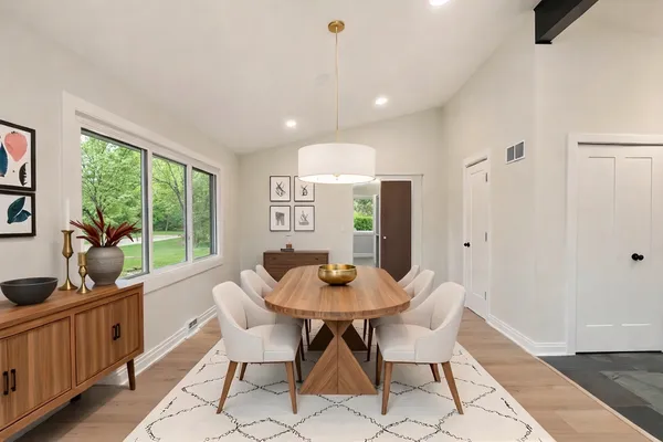 a dining room with furniture window and wooden floor