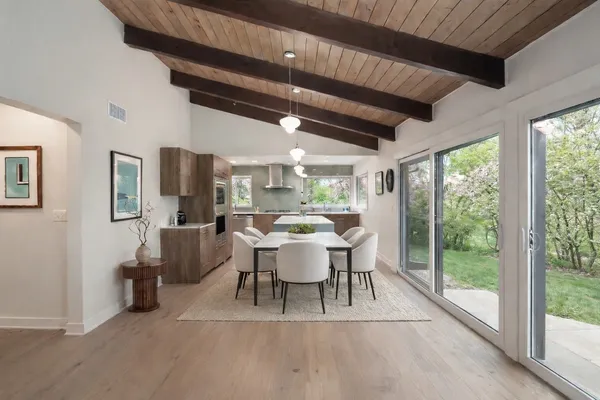 a dining room with furniture a large window and a rug