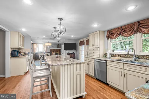 a kitchen with stainless steel appliances granite countertop lots of counter top space and wooden floor