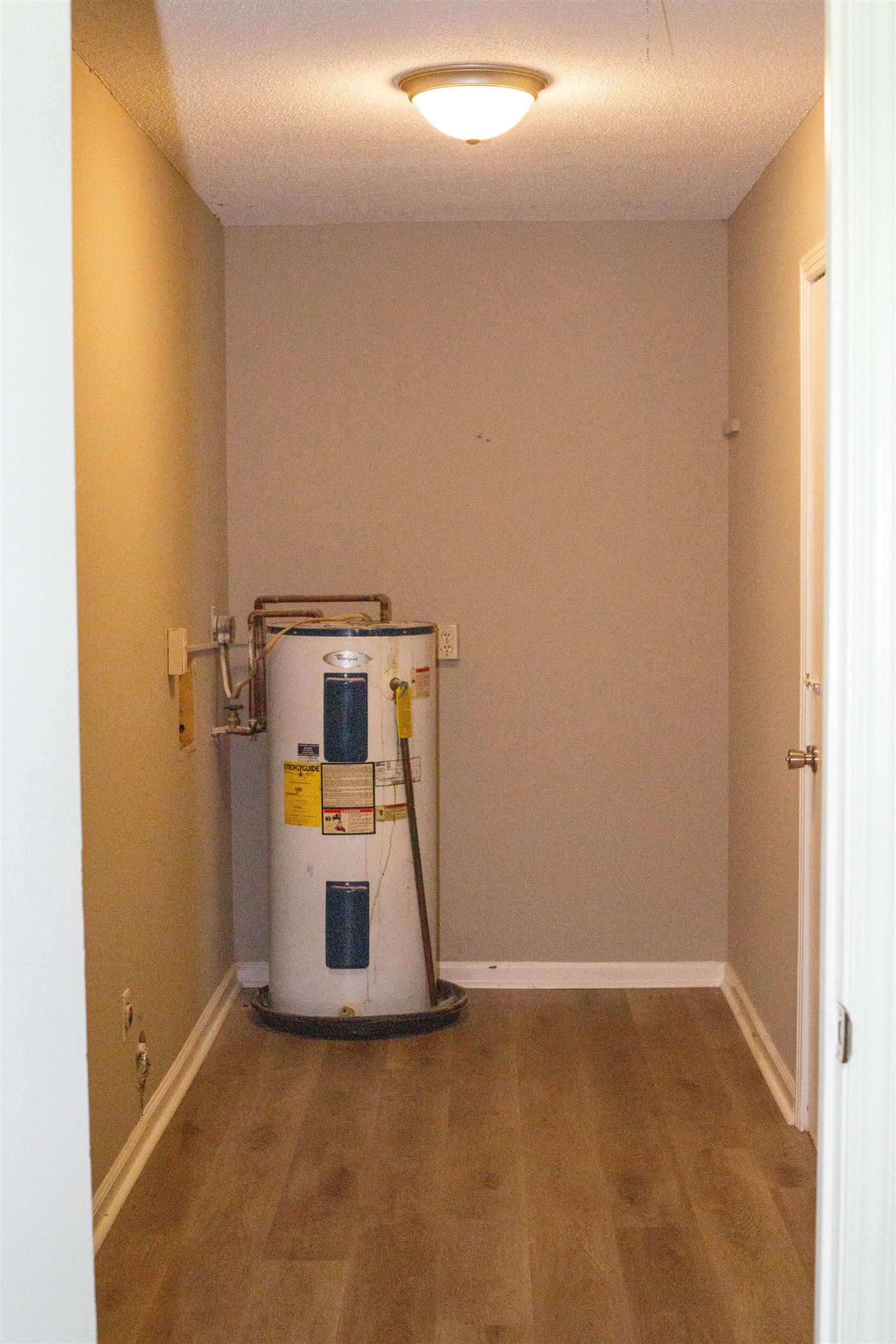 583 Armstrong Road Drummonds, TN 38023 - Photo 14 of 14 Utility area featuring wood-finish flooring, light tan wall paint, and white baseboards