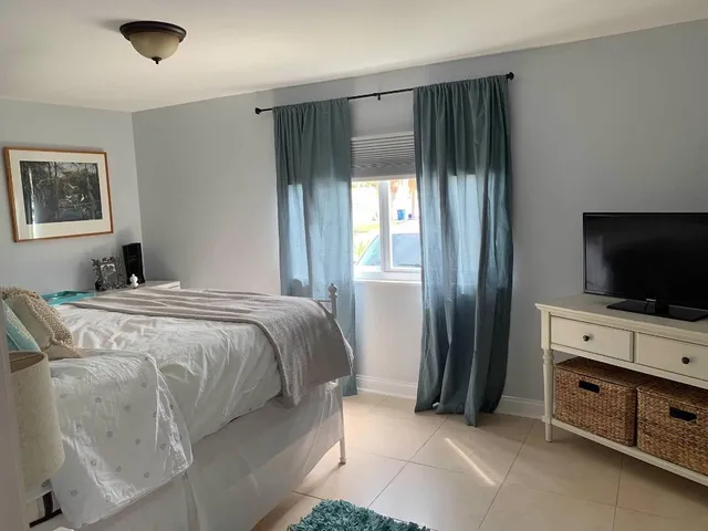 a bedroom with a bed and a flat screen tv