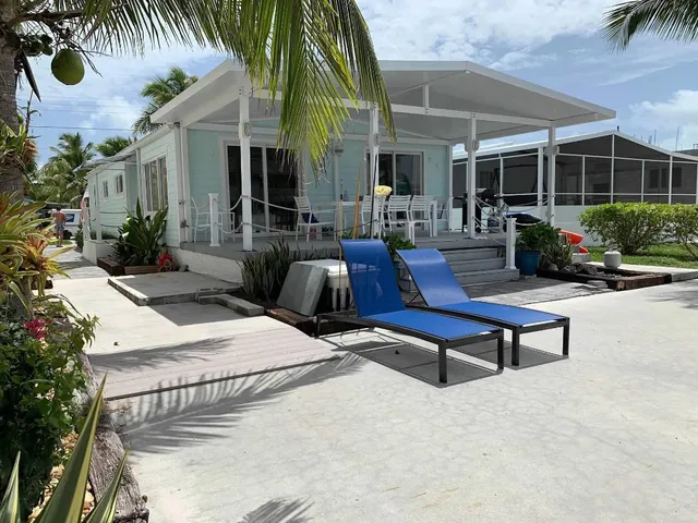 a view of a patio with couches table and chairs and potted plants