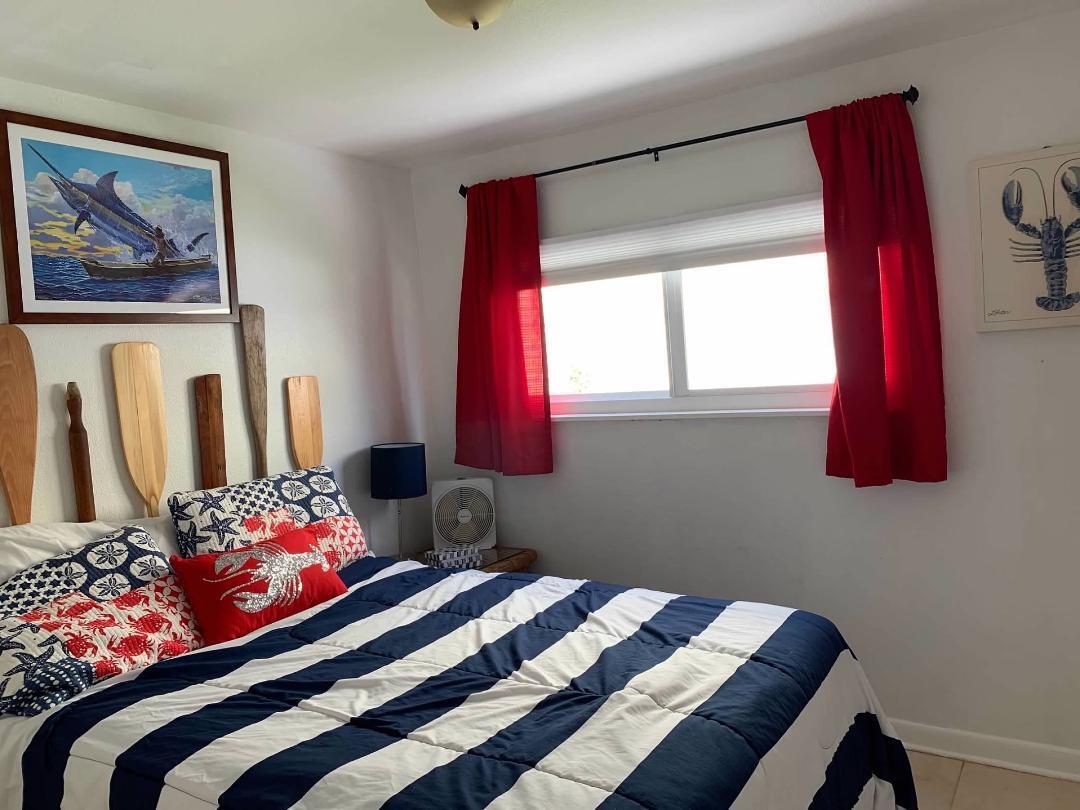 46 Ocean Drive Key Largo, FL 33037 - Photo 7 of 15 a bedroom with a bed and a painting on the wall