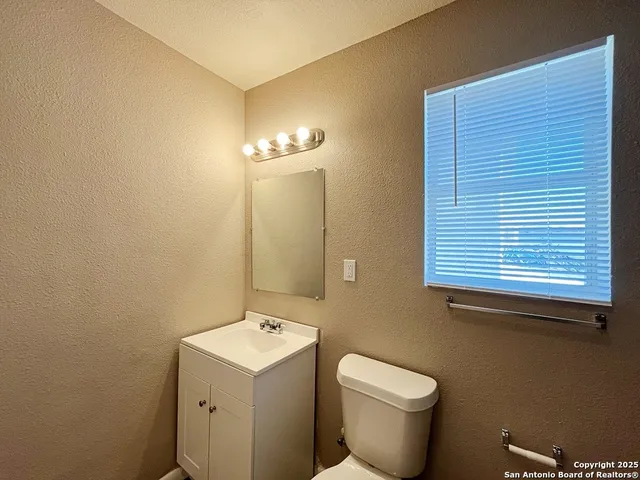 a bathroom with a toilet sink and mirror