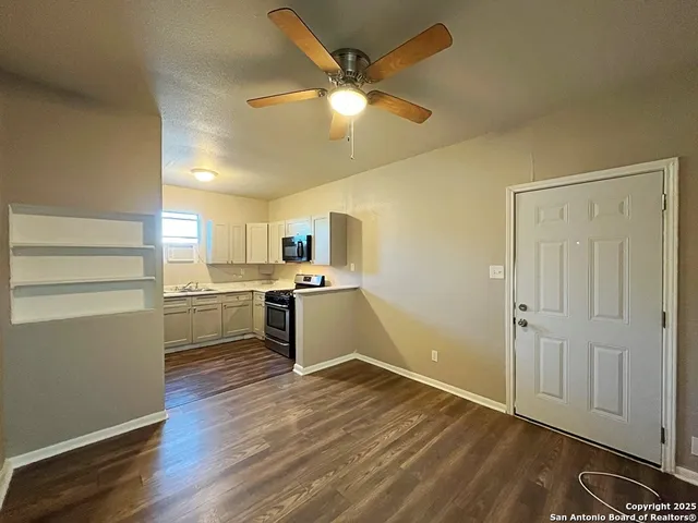 a kitchen with a refrigerator and white cabinets