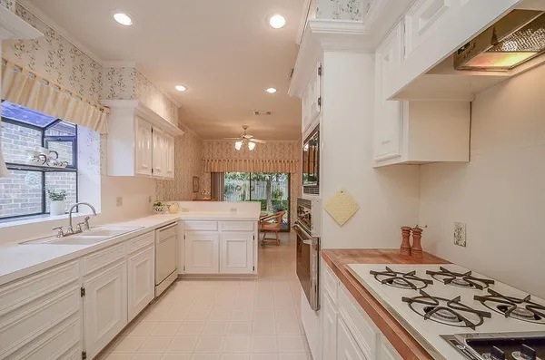 a kitchen with a sink stove and wooden cabinets