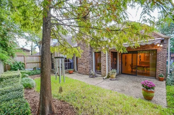 a view of a chair and table in backyard of the house