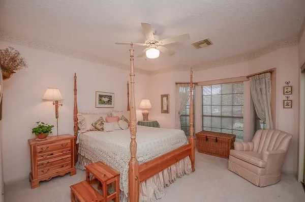 a bedroom with a bed couch and large window