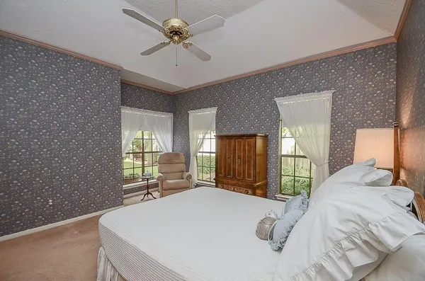 a bedroom with a large bed and a chandelier